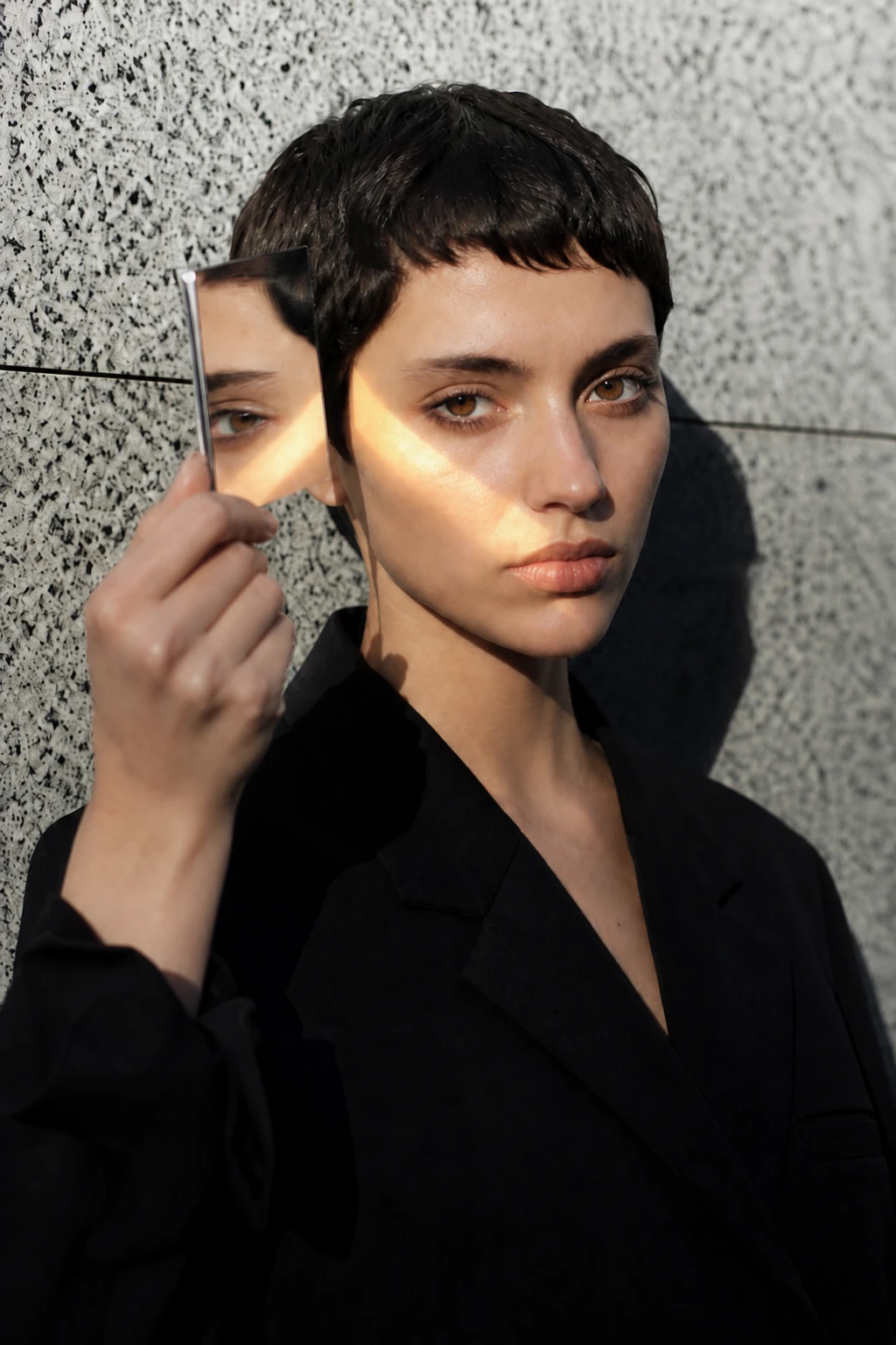 Use a warm gold board from low camera-left for a heated reflected patch against the cool concrete background Fashion model — Gold Board Heat variation of Mirror Bounce Sun Fashion.
