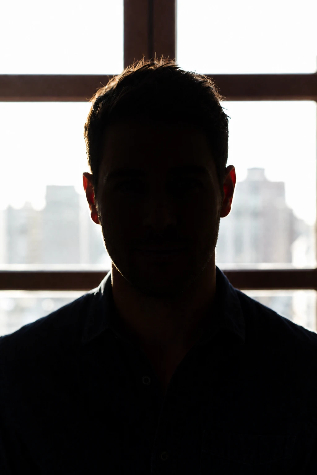 Remove the reflector and expose for the window — pure shape against glow Portrait subject — Full Silhouette variation of Window Backlit Reflector Portrait.