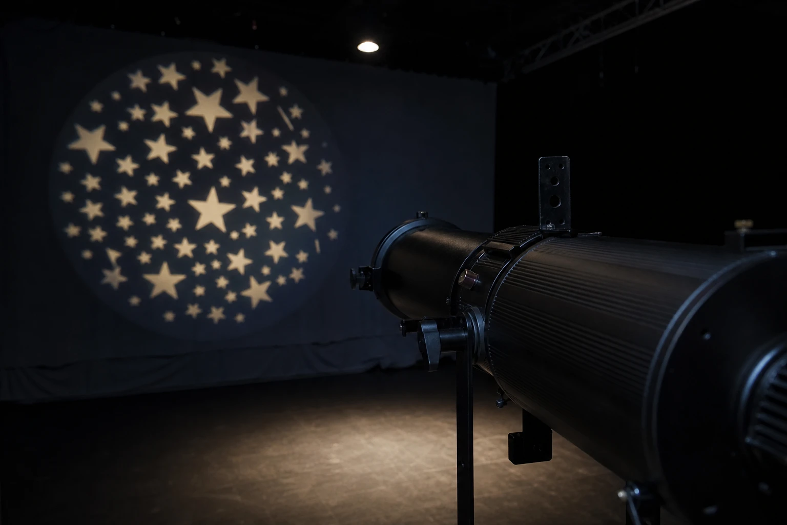 Optical spot / gobo, rigged as it is used — A focusing optical spot with a metal or glass gobo — a cut stencil, not a cinema projector