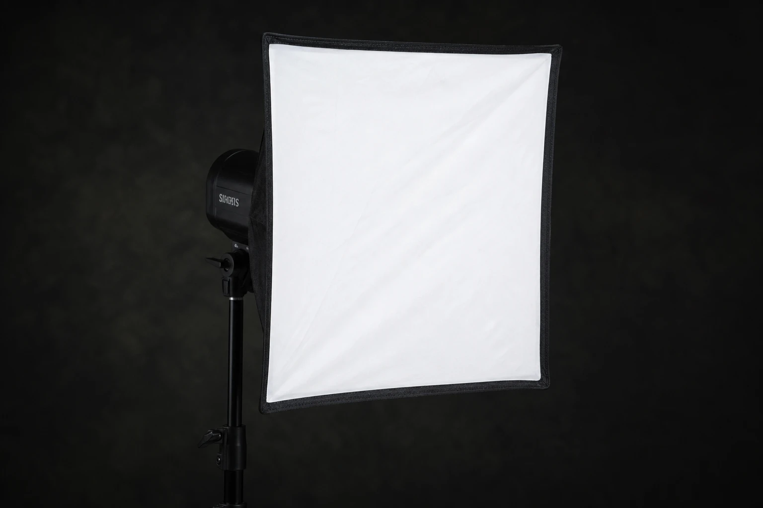 Softbox, rigged as it is used — A softbox is the default directional soft modifier — rectangular or square diffusion in front of flash with controlled spill compared to umbrellas