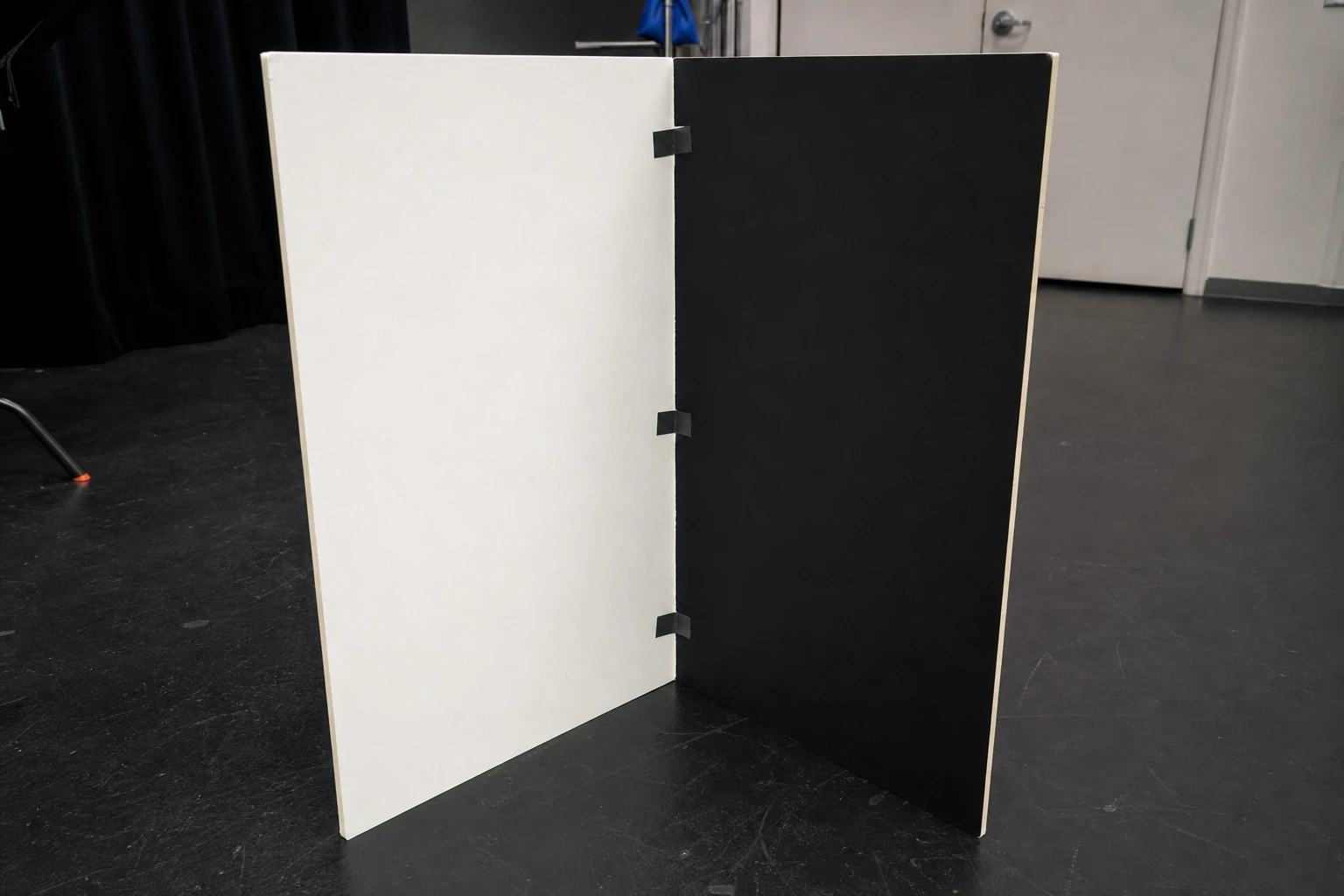 V-flat, rigged as it is used — V-flats are large folding panels — white bounce one side, black negative fill the other